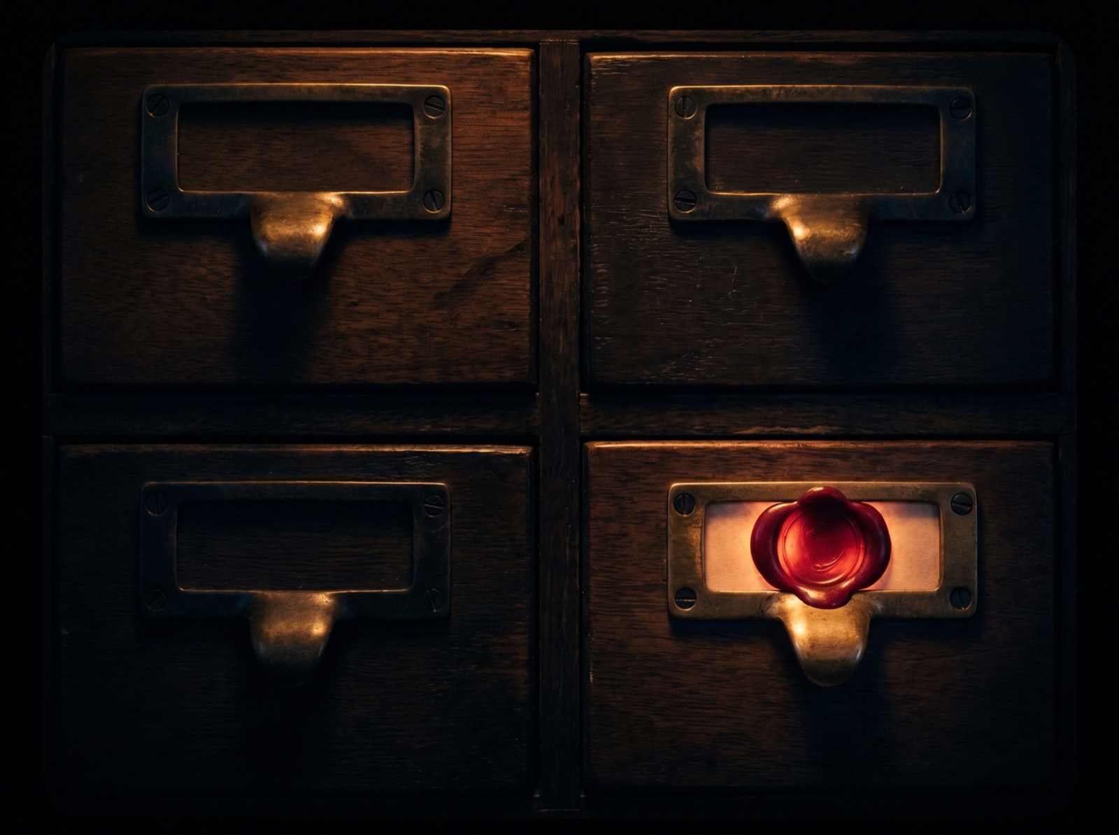 Four antique card-catalog drawers, one sealed with a glowing red wax seal